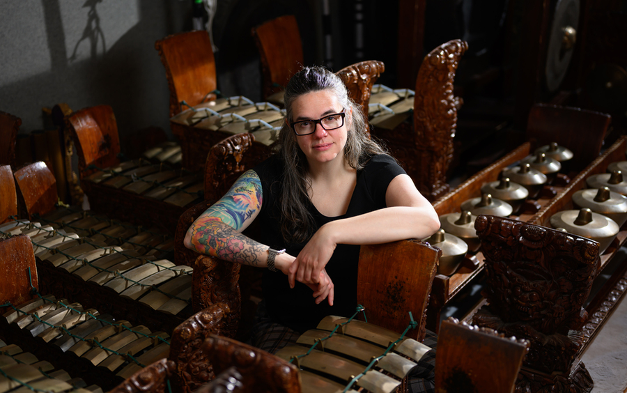 Faculty member surrounded by gamelan instruments.