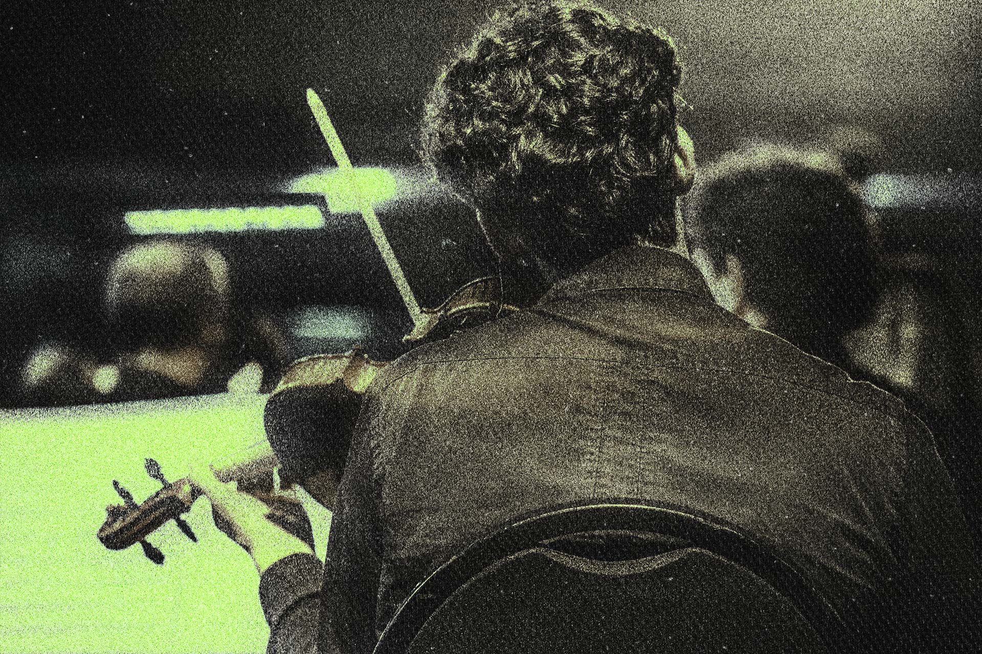 Back view of musician playing string instrument during concert.